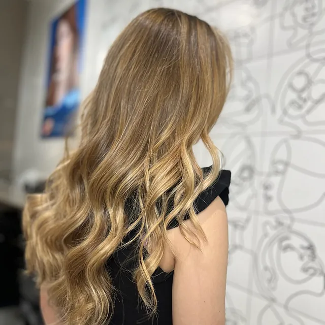 Moowe Stylists mujer de espaldas con pelo rubio rizado